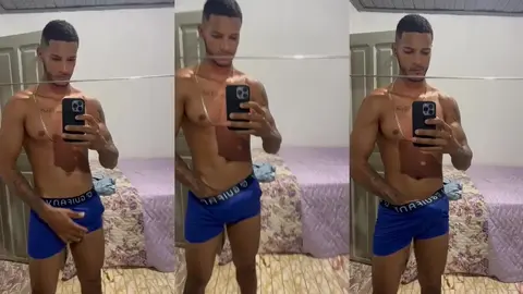 Un mec musclé en boxer bleu s'exhibe devant le miroir