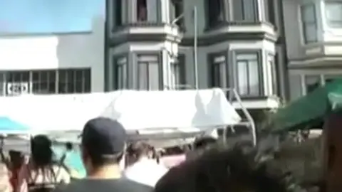 Homme Nu Repéré à la Fenêtre pendant une Fête de Rue