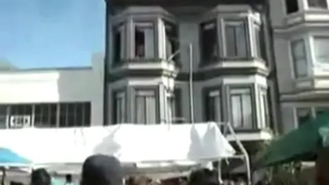 Homme Nu Repéré à la Fenêtre pendant une Fête de Rue