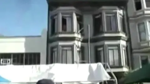 Homme Nu Repéré à la Fenêtre pendant une Fête de Rue