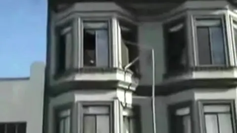Homme Nu Repéré à la Fenêtre pendant une Fête de Rue