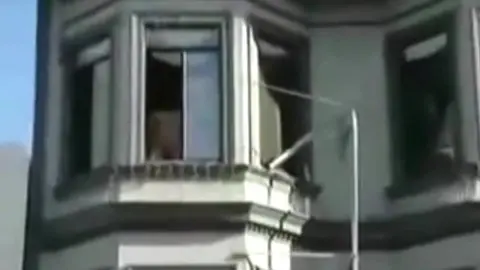 Homme Nu Repéré à la Fenêtre pendant une Fête de Rue
