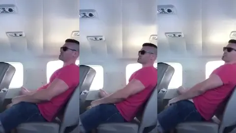 Un voyageur musclé en lunettes de soleil s'excite dans son siège d'avion